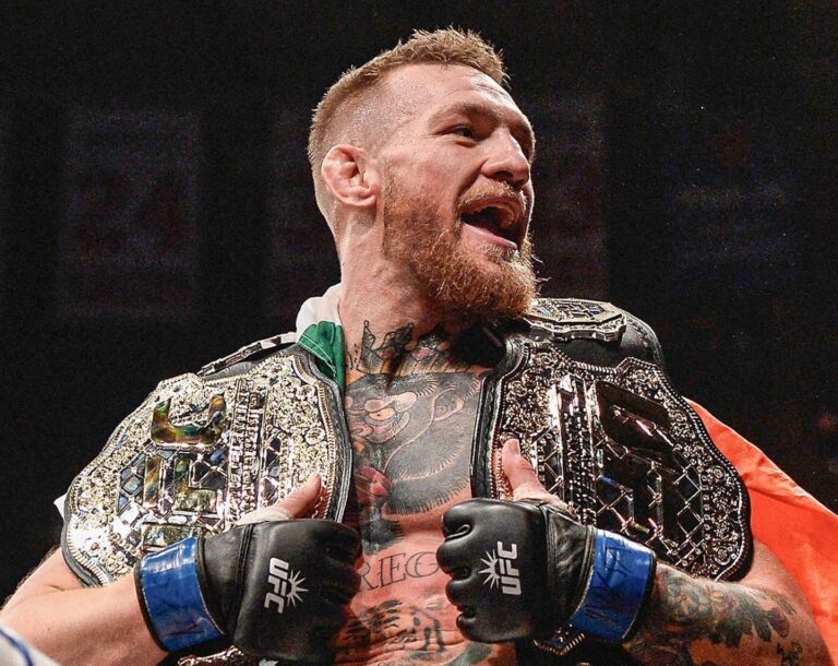 Conor McGregor holding his title belts