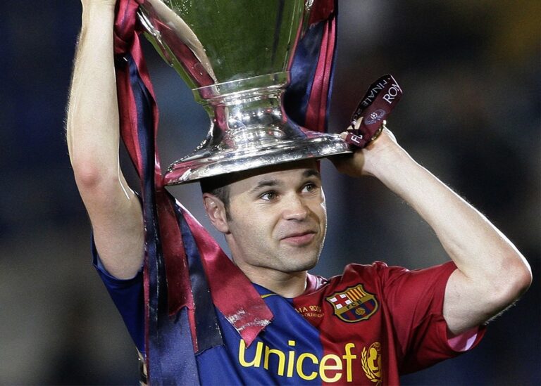 Andrés Iniesta holding trophy on his head