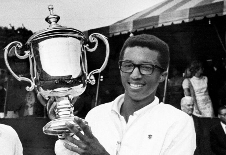 Arthur Ashe holds trophy