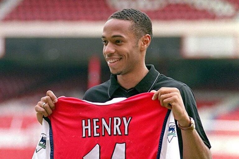 Thierry Henry holding his arsenal jersey